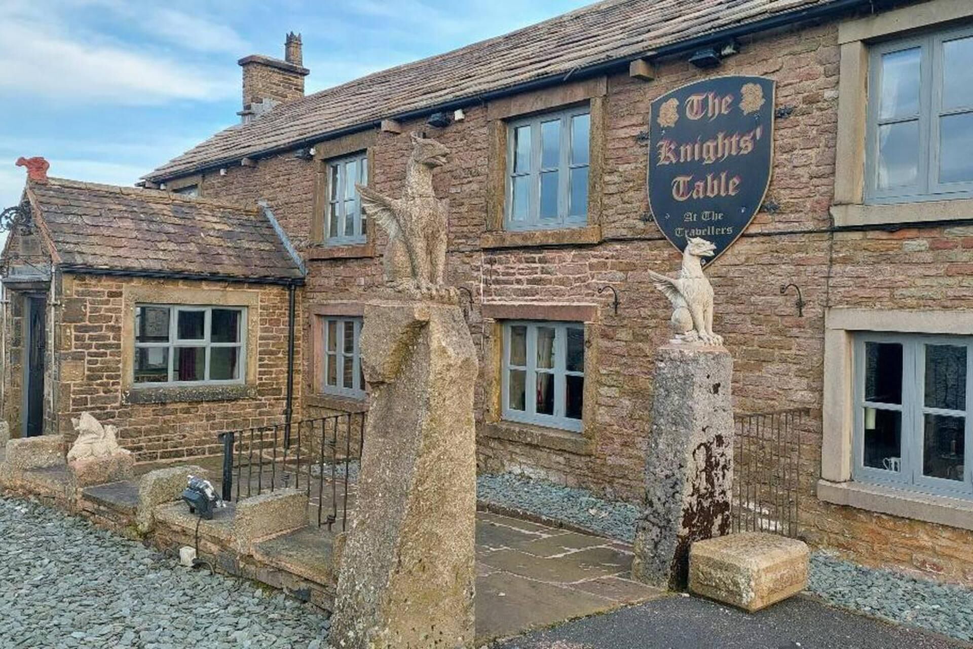 A traditional stone building with a sign reading "The Knights' Table."