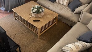 Ein Wohnzimmer mit einer Couch, einem Couchtisch und einem Fernseher.
