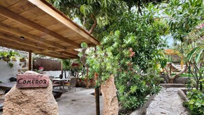 A covered outdoor area with a wooden pergola, a sign labeled 'COMEDOR,' and a stone pathway. - Vacation Home "Casa Candelaria" with Views of El Teide, Private Pool & Wi-Fi (Arico)