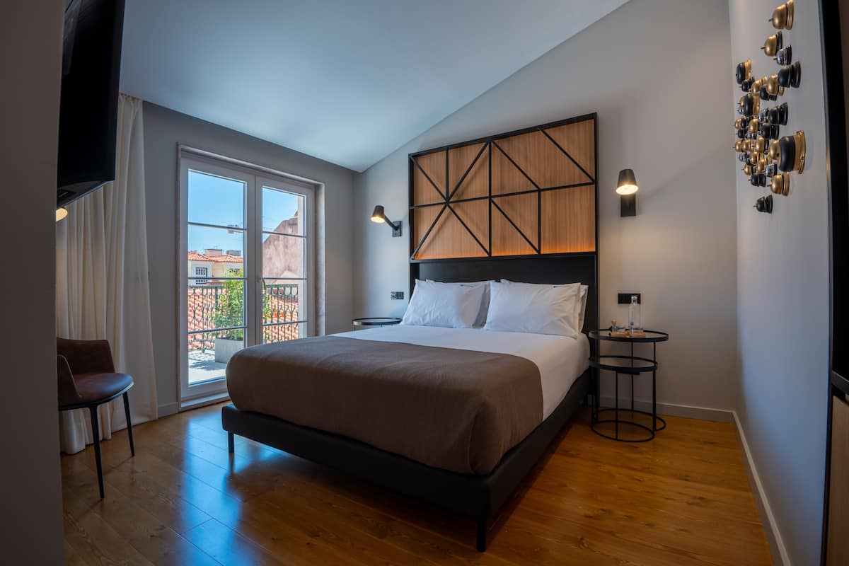Un dormitorio moderno con una cama grande, vistas a través de una puerta corredera y una mesita de noche pequeña.