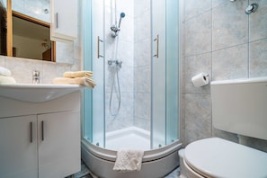 A modern bathroom with a glass-enclosed shower, a white sink, and a toilet. - Apartments Zarac (Dubrovnik)