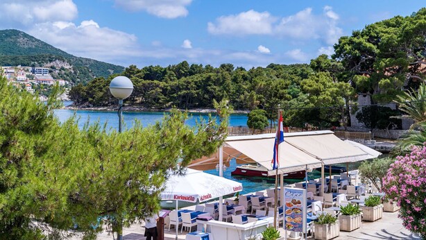 Une station balnéaire dotée d’une terrasse, d’une piscine et offrant une vue sur la mer et les montagnes.