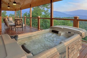 A hot tub on a wooden deck with a view of mountains. - Sunset Memories: Modern Lodge with Amazing Mountain Views (Gatlinburg)