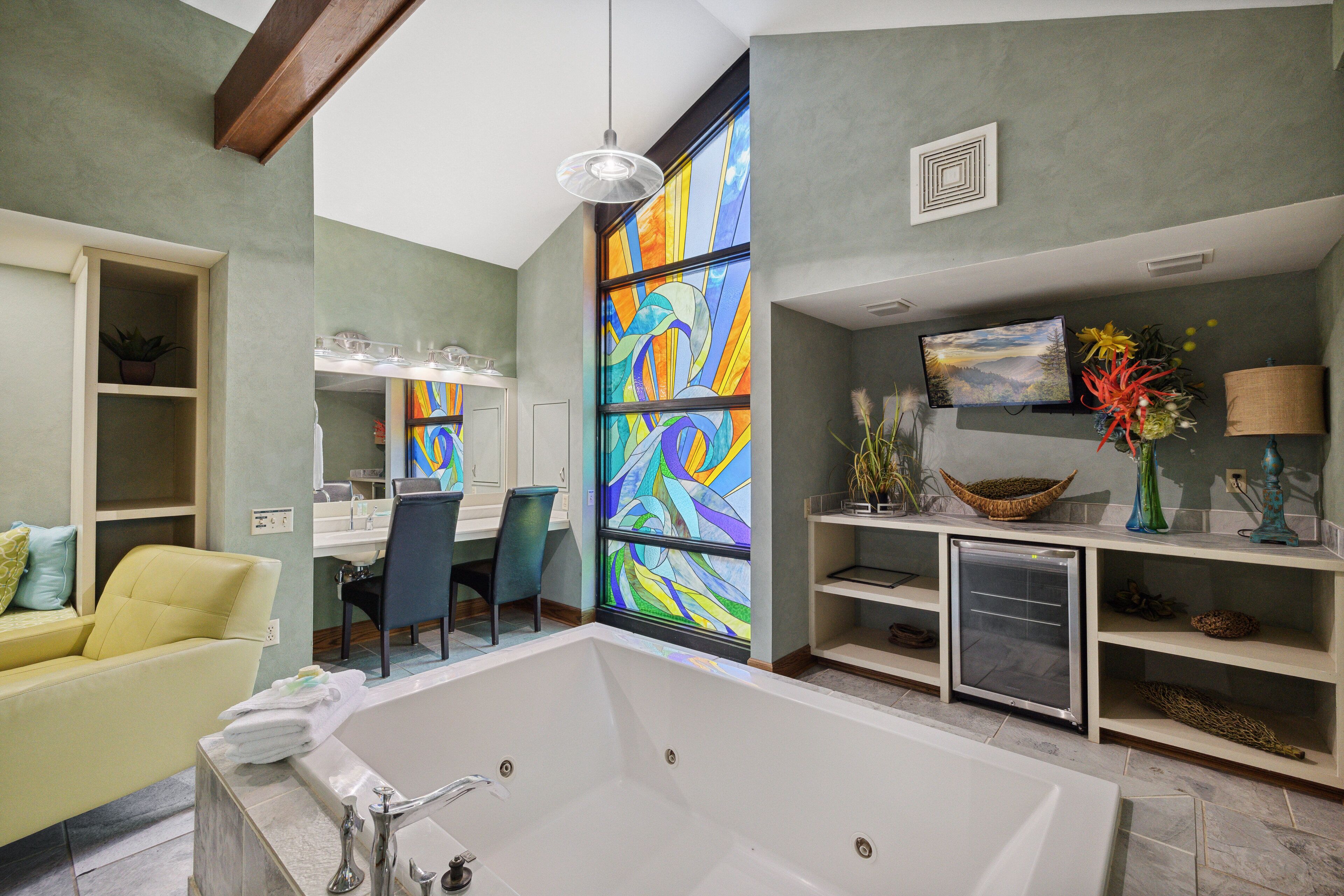 A modern bathroom with a large bathtub, a vanity with a mirror, and a shower area.