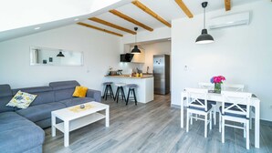 A modern apartment with a living room, kitchen, and dining area. - Apartments Amalija (Konavle)