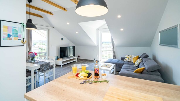 A modern loft apartment with a dining area, a sofa, and a TV. - Apartments Amalija (Konavle)