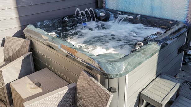 A hot tub with a cover, a control panel, and a faucet. - Cliff House (Saltburn-by-the-Sea)