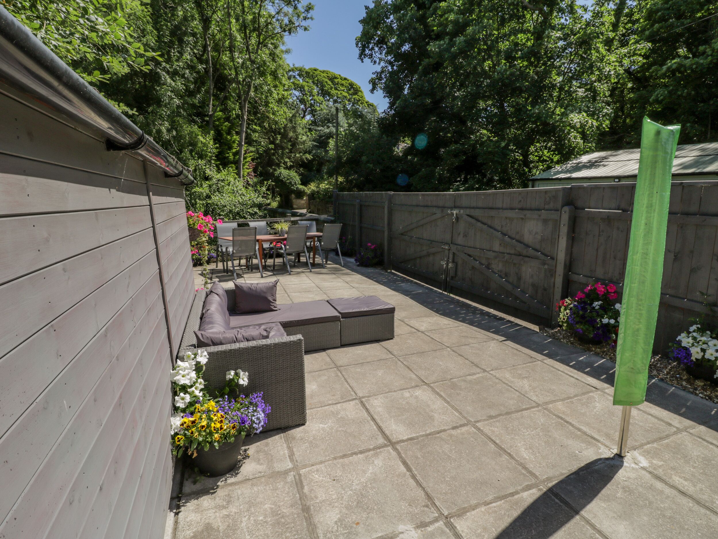 A patio with a seating area, a table, and chairs.