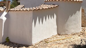 Een gebouw met een witte gevel en terracotta dakpannen.