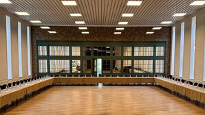 A spacious conference room with a long table, high ceilings with linear lighting, and large windows. - Park Resort Aghveran (Arzakan)