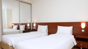 A hotel room with two single beds, a wooden headboard, bedside tables, and a large mirror. - Park Resort Aghveran (Arzakan)
