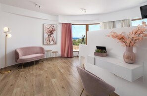 A modern living room with a pink sofa, a white console table, a floor lamp, a painting, and a view of the outdoors.