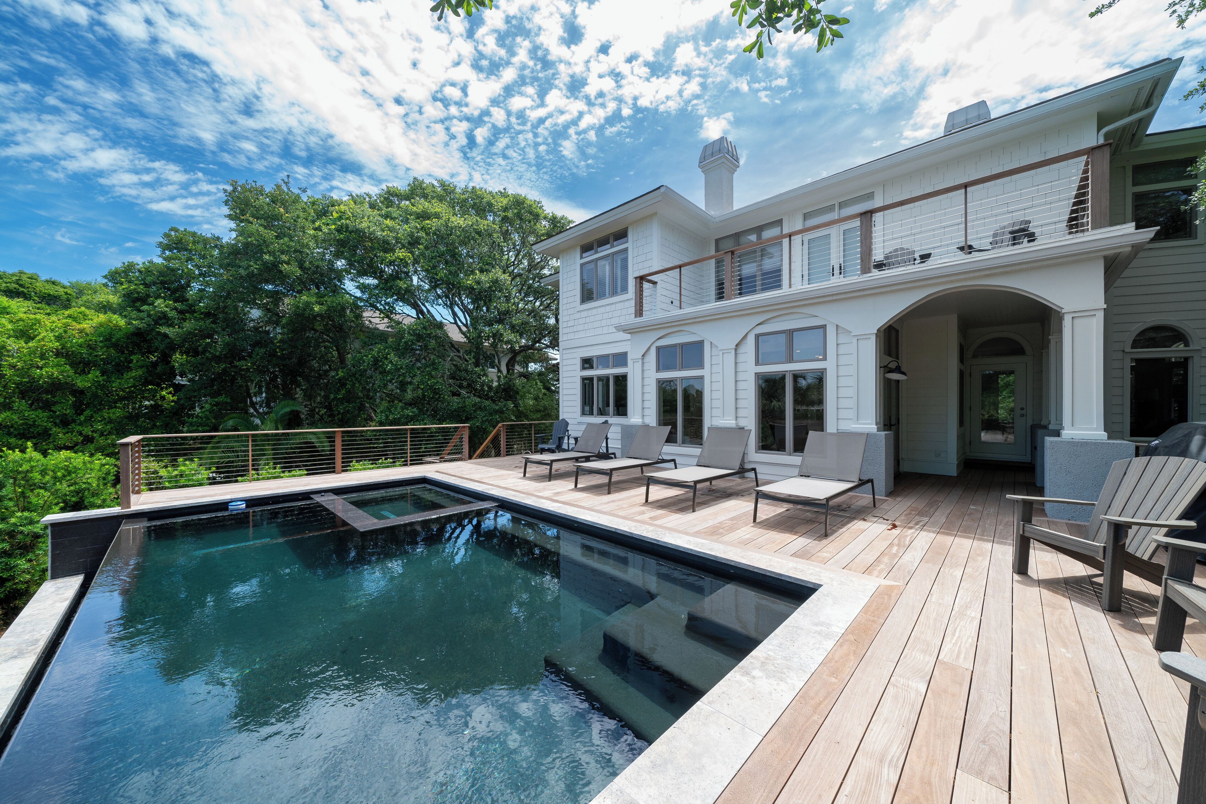 A two-story house with a swimming pool and outdoor seating area.