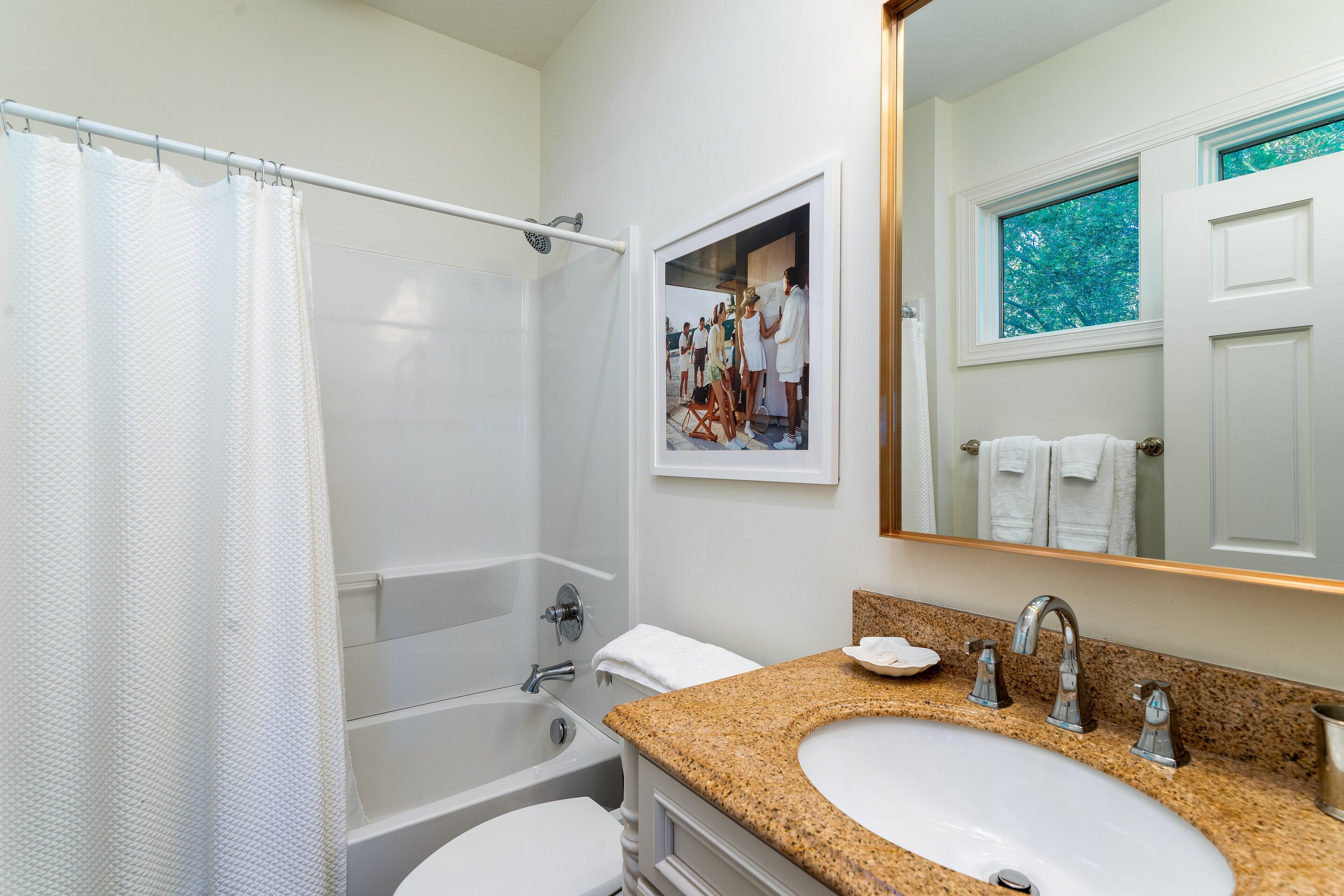Un baño con bañera, inodoro y lavamanos.