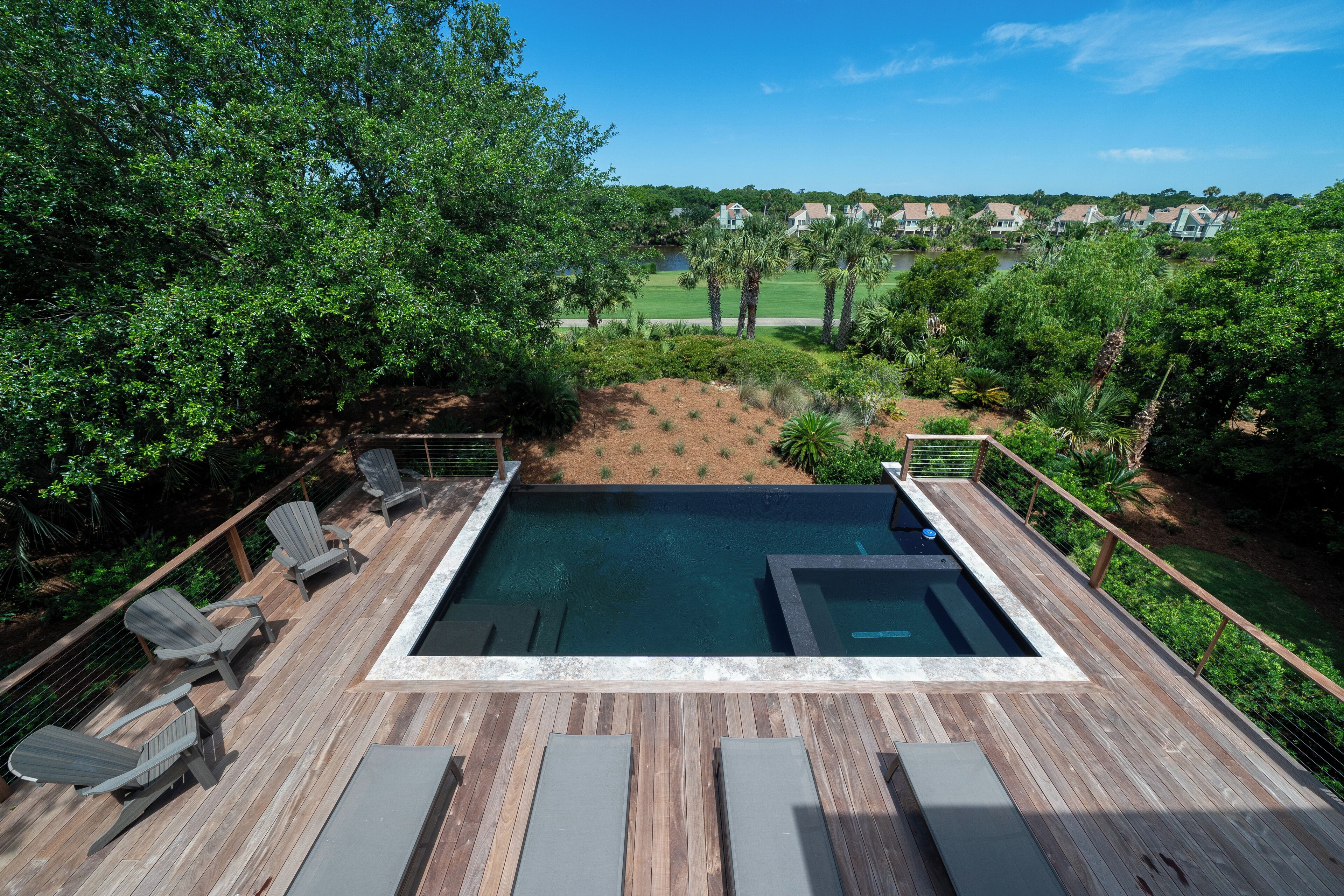 Une piscine avec des chaises longues et une terrasse.