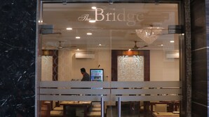 A hotel entrance with a glass door, a visible interior dining area, and a ceiling fan. - Hotel Clarks Inn Express Bharatpur (Bharatpur)