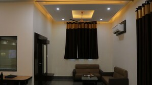 A modern living room with a sofa, a coffee table, and a ceiling fan. - Hotel Clarks Inn Express Bharatpur (Bharatpur)