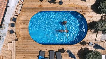 Una piscina al aire libre, sillones reclinables de piscina