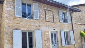 A stone building with white shutters, a balcony, and a gated entrance. - Stone house with jacuzzi 500m from the Ain 3bed 8p (Poncin)