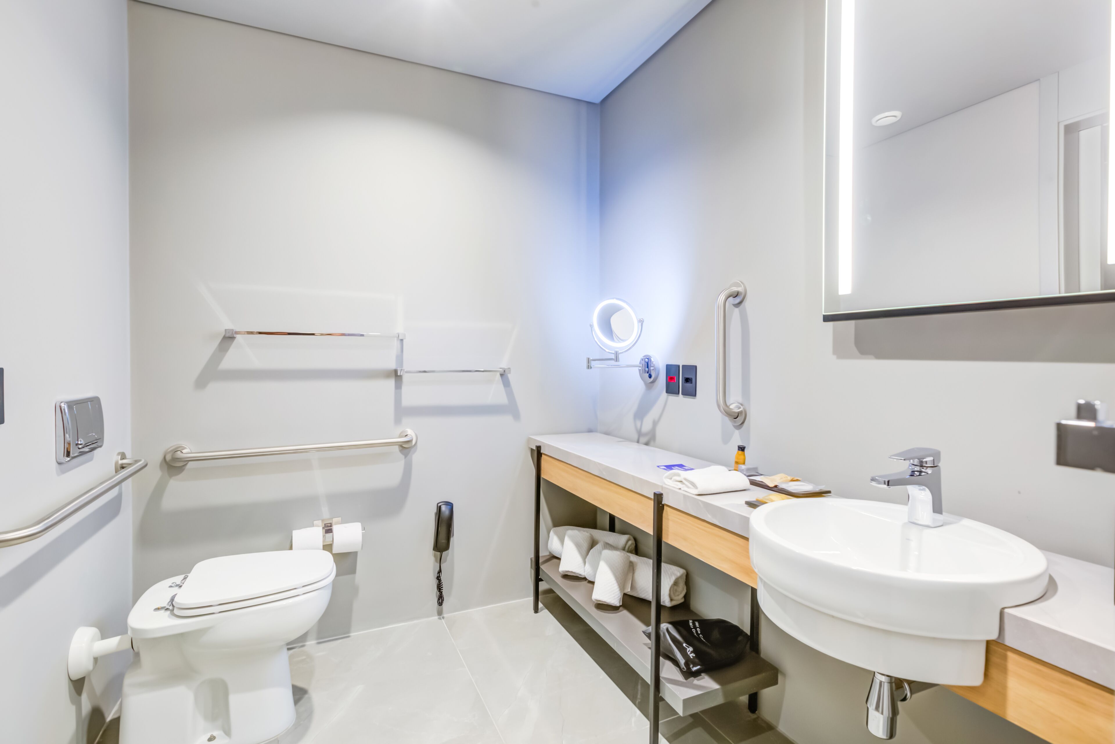 A modern bathroom with a toilet, sink, and vanity.