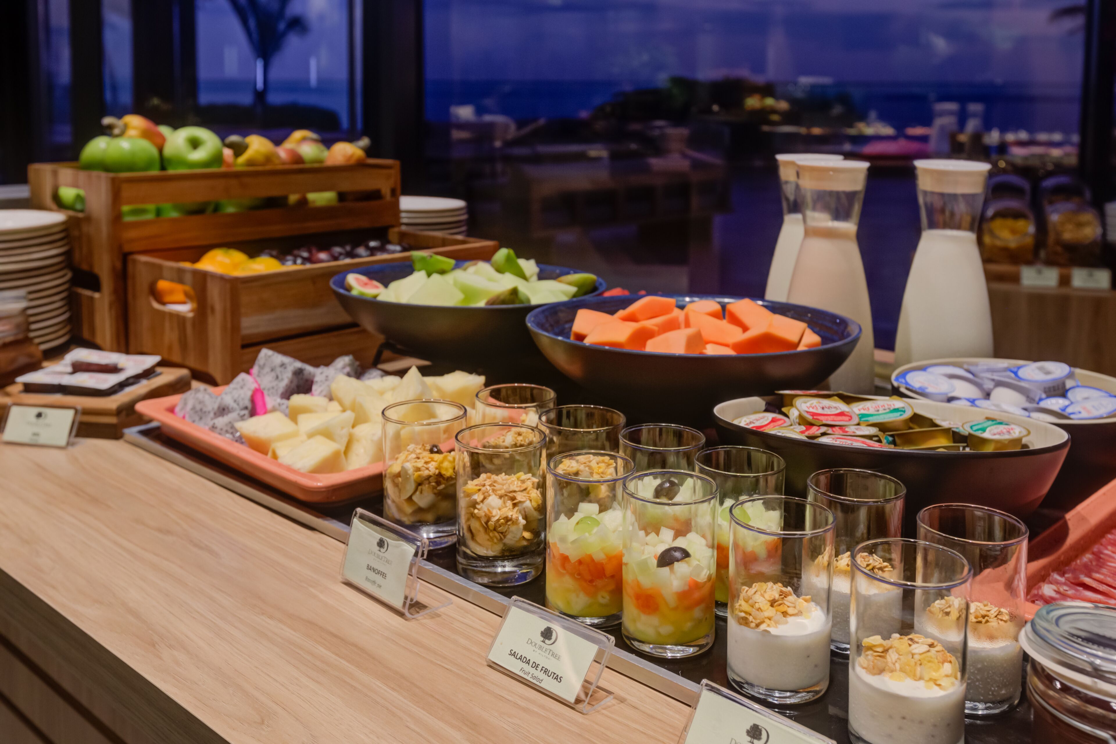 A buffet with various fruits, vegetables, and prepared dishes.
