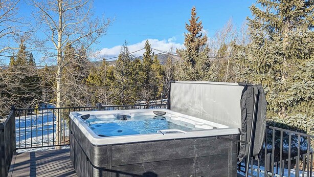 A hot tub on a wooden deck with a view of trees and mountains. - 602 West 8th — 4BR Leadville Home, Hot Tub, Deck, Dogs OK, On the Mineral Belt (Leadville)