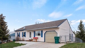 A single-story house with a garage, a front yard, and a satellite dish. - 602 West 8th — 4BR Leadville Home, Hot Tub, Deck, Dogs OK, On the Mineral Belt (Leadville)