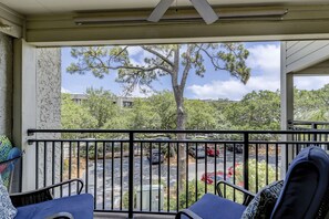 Relax in an outdoor seating area with a view of the surrounding trees and parking lot.
