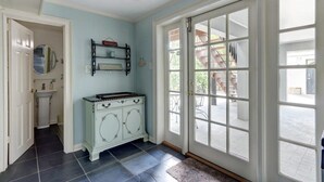 Ein Zimmer mit einer weißen Tür, einer blauen Wand, einem weißen Schrank und Blick nach draußen.