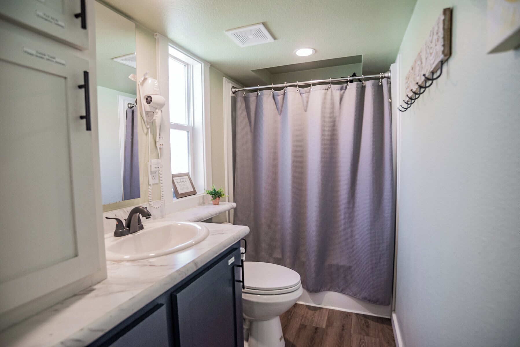 A bathroom with a white sink, a toilet, and a shower curtain.