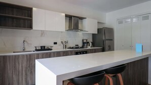 A modern kitchen with a central island, stainless steel appliances, and wooden cabinetry.