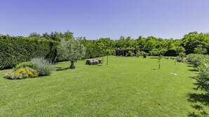 A well-maintained garden with a variety of plants and a small structure. - ADRIA house with apartments / Adria APARTMENT C3 (Umag)