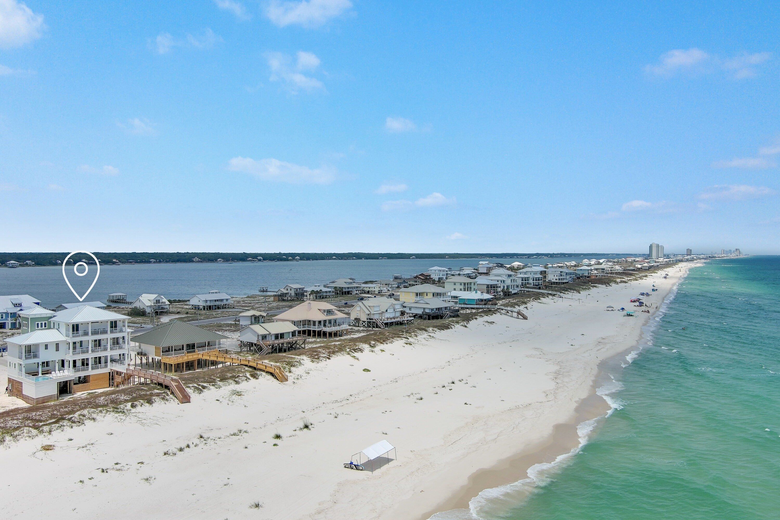 A beachfront property with multiple buildings, a sandy beach, and a view of the ocean.