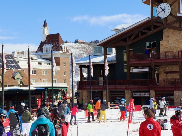 Estación de esquí con comedor, un reloj y un edificio con un letrero que dice "PARK CITY LEGACY LODGE".