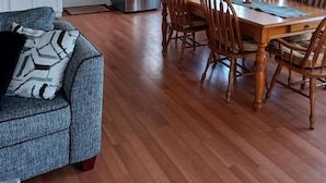 Une cuisine compacte équipée d’un réfrigérateur, d’une cuisinière et d’un coin repas avec des chaises et une table en bois.