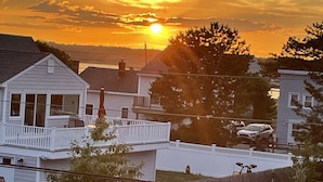 Un quartier résidentiel avec des maisons, une clôture en bois et un ciel dégagé au coucher du soleil.