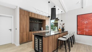 Eine moderne Küche mit Holzausstattung, einer zentralen Kochinsel und einem Essbereich mit Stühlen.