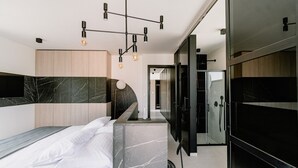 Een moderne slaapkamer met een bed, een kaptafel en een inloopkast.