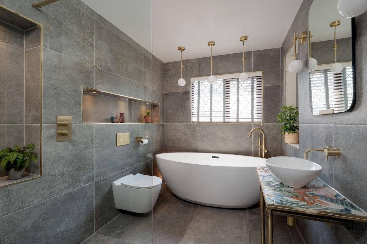 A modern bathroom with a freestanding bathtub, a white sink, and a large mirror.