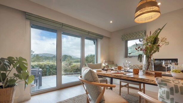 A spacious dining area with a large table, chairs, and a view of the outdoors. - Barakat Lakes Escape | Ridgestone (Ambleside)