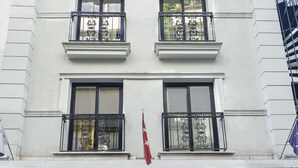 Un edificio blanco con varios balcones y ventanas amplias, que muestra el letrero "UK Istanbul Hotel".