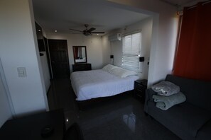 A bedroom with a bed, bedside tables, a ceiling fan, a window with blinds, and a red curtain. - Luxury Romantic Villa in Escazu w/Jacuzzi & Views (Escazú)