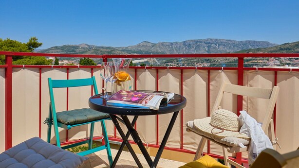 A balcony with a table, chairs, and a view of the mountains. - Joyful Place (Dubrovnik)