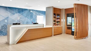 A reception area with a wooden counter, a wall with text, and a vending machine.