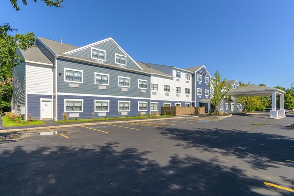 A multi-story hotel with a parking lot in front.