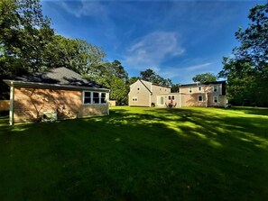 A two-story house with a well-maintained lawn and a large driveway.