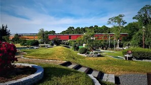 A landscaped garden with a pathway, a building with a red roof, and a sign with the number 35. - Beautiful home!!! Private game room, swimming pool and pets allowed. (Sandwich)