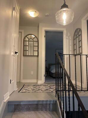 Stylish hallway leads to a cozy bedroom with a comfortable bed.