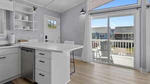 Una cocina moderna con armarios blancos, lavavajillas integrado y una isla grande con asientos.