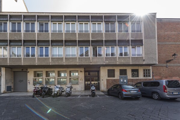 A multi-story building with a row of windows on the ground floor.